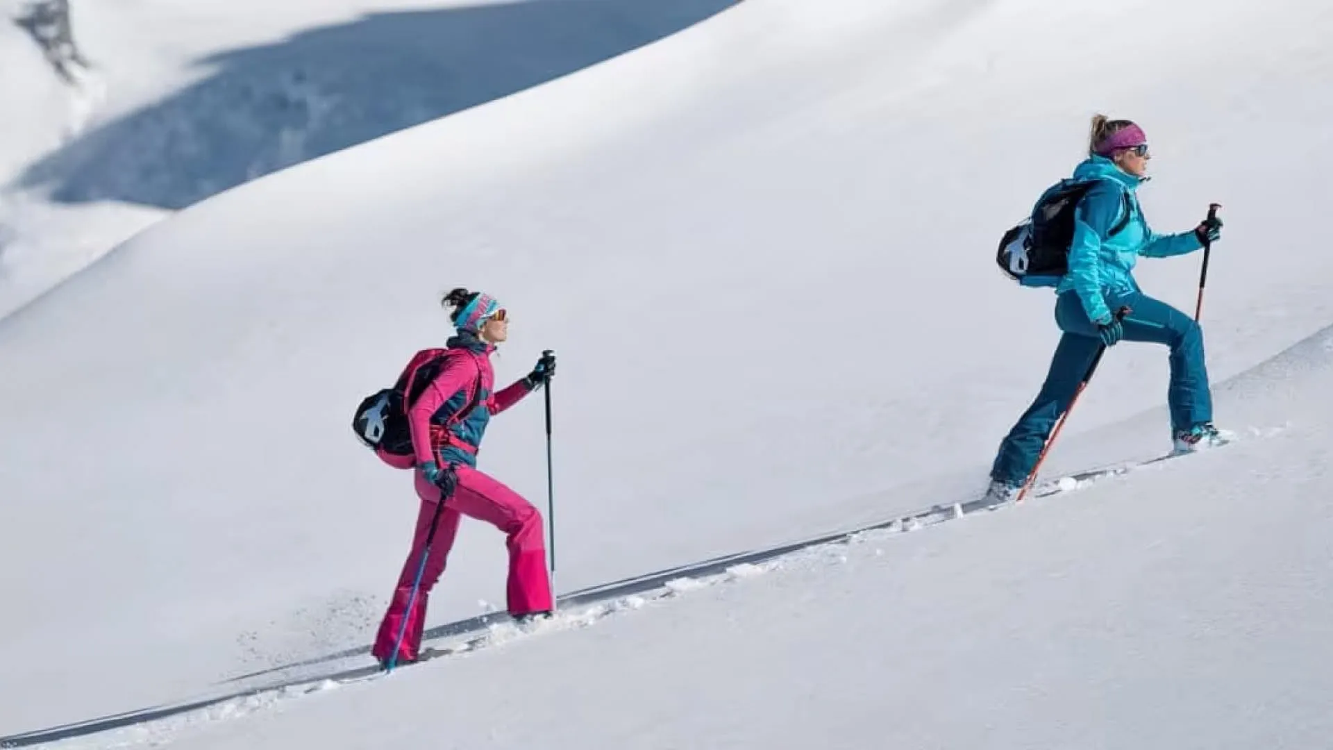 Drei Skifahrer auf verschneitem Hang unterwegs
