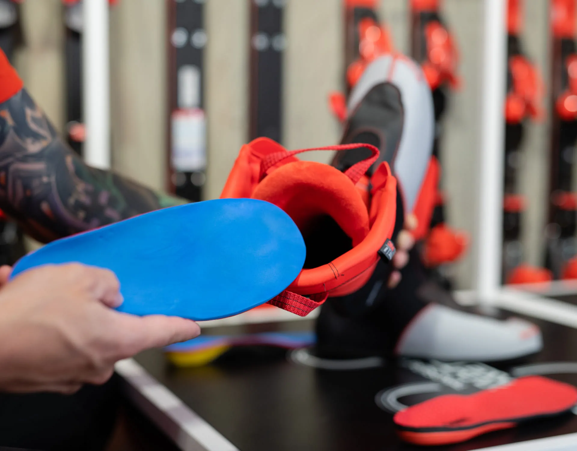 Hände halten roten Schuh mit blauer Einlage